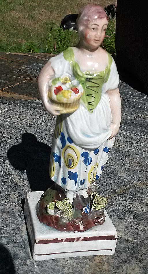 Figure of girl with basket of fruit