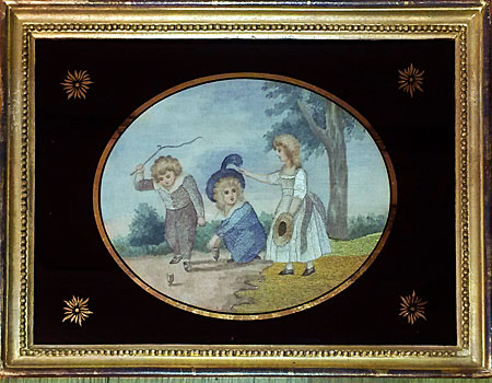 Pair of silk needlework pictures of children playing