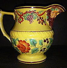 SOLD Yellow-glazed jug with masks